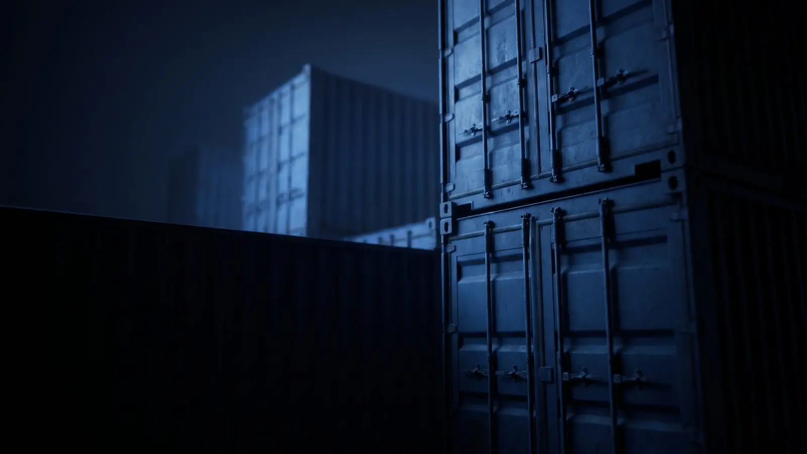 Shipping containers stacked against a night sky, lit blue from below.