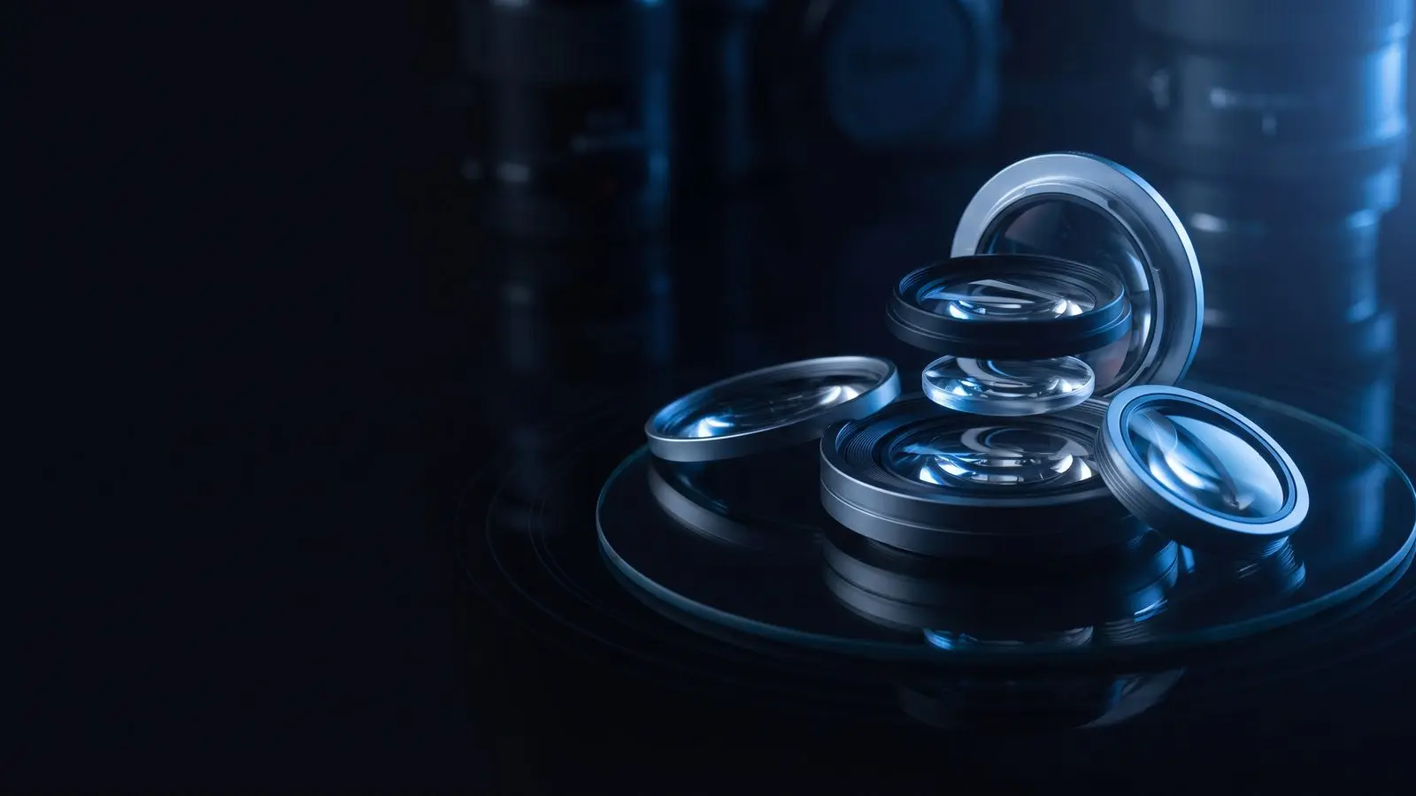 Camera lens elements stacked on dark glass with blue reflections.